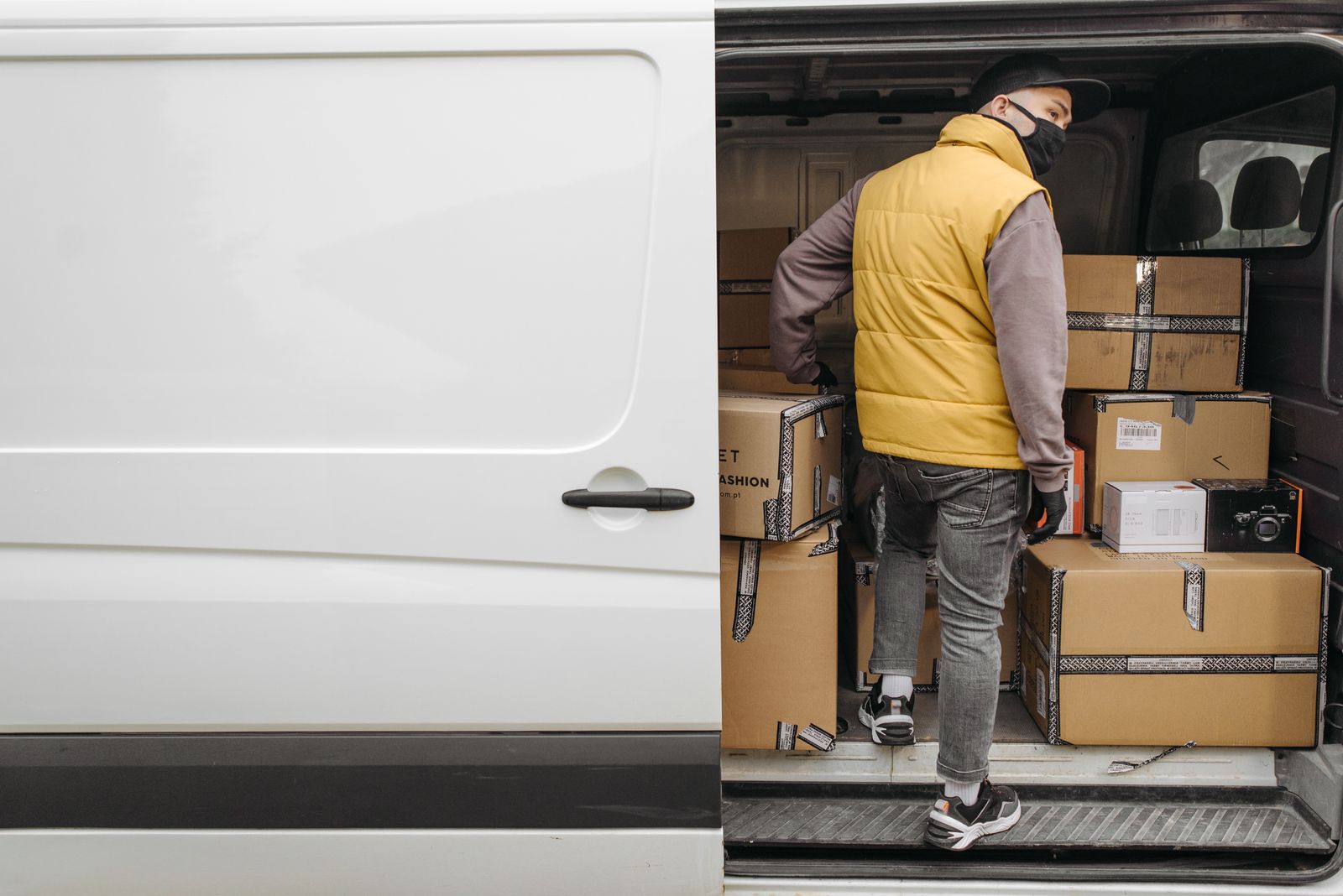 Mitarbeiter belädt einen weißen Transporter mit Kartons bei einer Entrümpelung